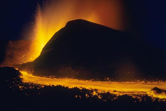 Lava fountains from the new cone of Mikombe on the lower NE flank of Zaire's Nyamuragira volcano feed the lava flow in the foreground.